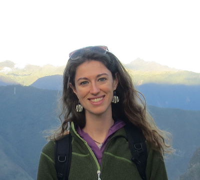 Rachel Wood stands smiling with mountain peaks in the background.